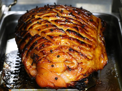 honey glazed gammon ham with traditional herbs and spicesin a roasting tray,Cooked meat for festive seasons