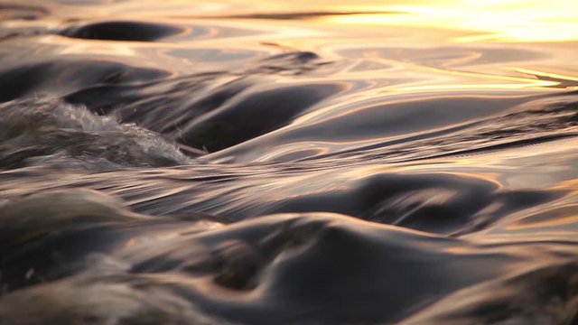 water in a river flowing over rocks in the morninglight