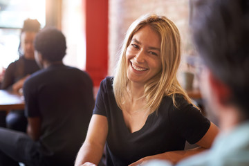 Couple Meeting And Chatting In Coffee Shop Sitting At Table