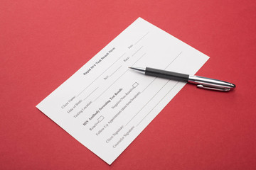 rapid HIV test result form with pen on red background