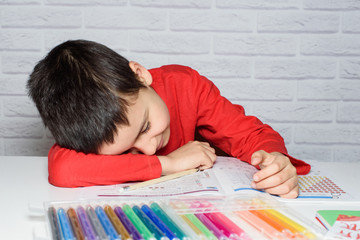 Upset boring schoolboy doing homework. Education, school, learning difficulties concept.