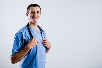 Portrait of happy smiling male doctor intern holding stethoscope isolated on white background