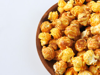 Top view of delicious popcorn in round wooden plate isolated on white background. Include buttery caramel corn and rich cheddar cheese corn. Food and snack concept.