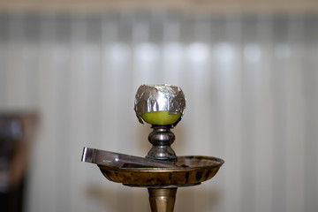 Bowl and head of Syrian hookah made of green apple, with foil on it. After use.