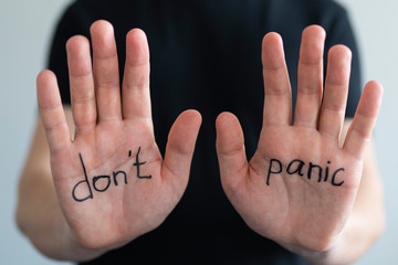 Don't panic. Text on men's hands, close-up. The concept of the coronavirus epidemic and the crisis