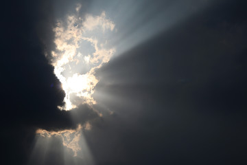 Fototapeta premium The light shone through from a dark cloud. The sun shines through the dark clouds. 