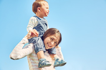 young mother playing with her baby. Mom and son outdoors.