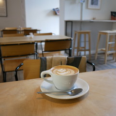 flat white artisan cup of coffee on wooden table