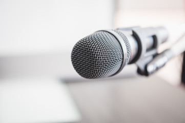 Fototapeta premium Closeup of microphone in lecture room background speech in seminar convention hall room. Mic speaker of teacher on podium in college or university. Workshop event and Entertainment broadcast concept.