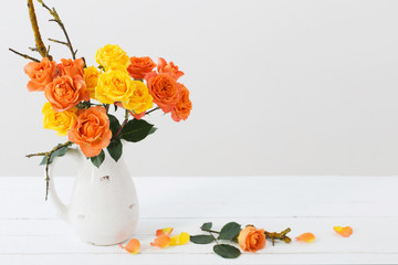 roses in white jug on white background