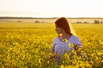 sexy redhead woman outdoors. Beautiful stylish romantic young girl in yellow field.