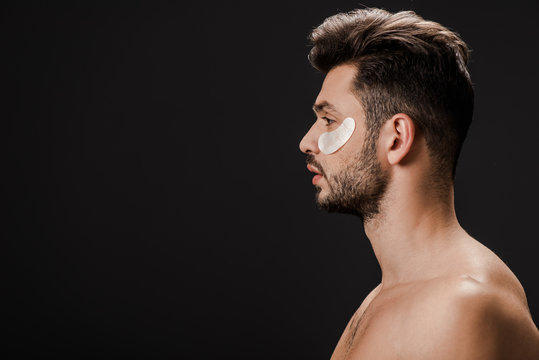side view of sexy naked man with eye patches on face isolated on black