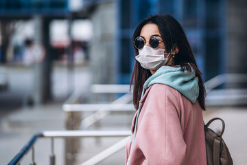 Female in medical mask outdoors in the empty city. Health protection and prevention of virus outbreak, coronavirus, COVID-19, epidemic, pandemic, infectious diseases, quarantine concept.