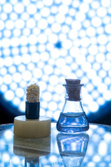 Test tubes and medicine pills on blue laboratory background