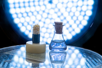 Test tubes and medicine pills on blue laboratory background
