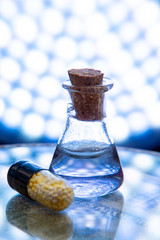 Test tubes and medicine pills on blue laboratory background