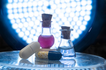 Test tubes and medicine pills on blue laboratory background