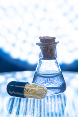 Test tubes and medicine pills on blue laboratory background