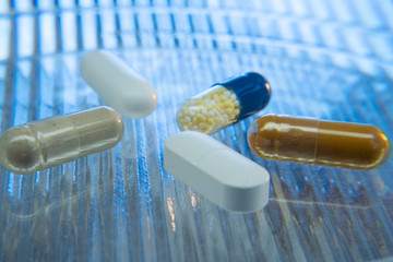 Color medicine pills on blue laboratory table