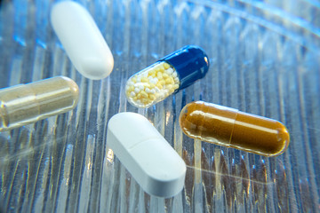 Color medicine pills on blue laboratory table