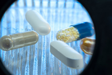 Color medicine pills on blue laboratory table