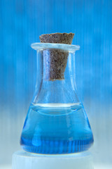Test tube with color solution on blue laboratory background