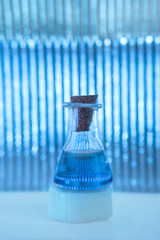 Test tube with color solution on blue laboratory background