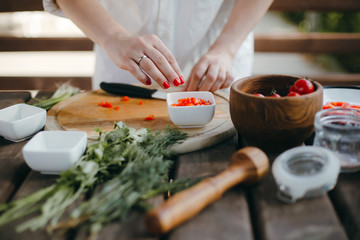 Obraz na płótnie Canvas Woman's hands chopping vegetables on wooden plate. Healthy vegetarian food