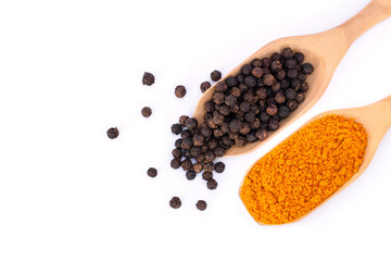 Curcumin powder ( tumeric ground, turmeric,Curcuma )  and black pepper corn in wooden spoon  isolated on white background. Health benefits and antioxidant food concept. Top view. Flat lay. 