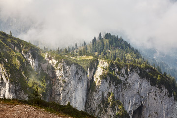 scenic mountain landscape with clouds, forest and grass.