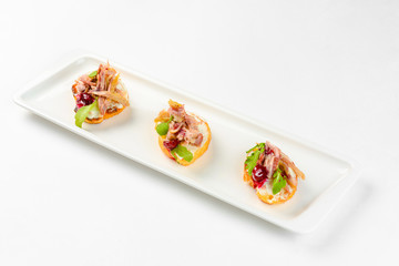 Appetizer sandwiches on a white plate on a white background. Catering service
