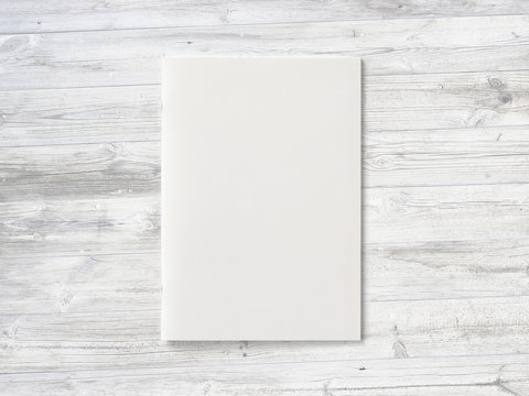 Blank Magazine or Brochure on wooden background. Front cover top view as mockup template for your design presentation
