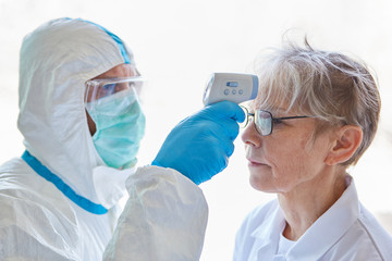 Fieber messen an Stirn bei Covid-19 Patientin in Klinik