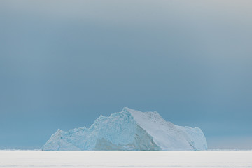Iceberg on frozen sea, Greenland