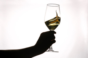 Female hand holding glass with white wine toasting isolated on a white background