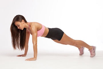 Fototapeta na wymiar Beautiful brunette doing some push ups. Fitness woman doing push ups.