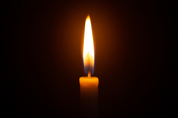 Red candle with yellow flame on black background 