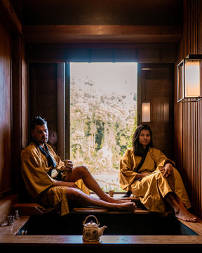Chiang Mai, Young couple men and woman relaxing in spa, Onse wooden bath tub,bath at hot springs in Chiang Mai Thailand