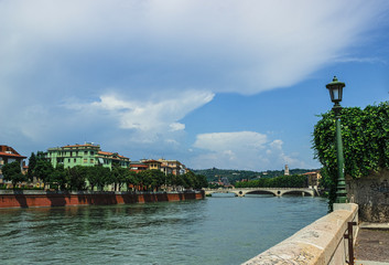 View of the Adige river and the Ponte della Vittoria bridge . Verona. Italy. Soft focus, blurry background.