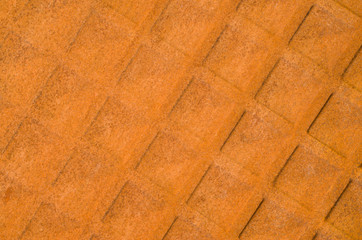 Old rusty metal surface with square ornaments closeup