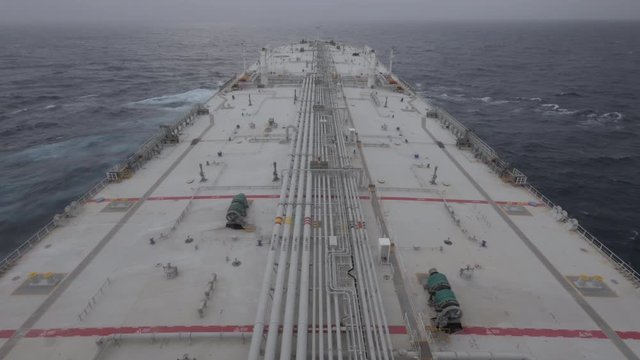 Large tanker ship sails in ocean in cloudy day