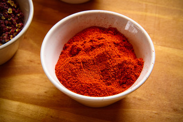 paprika powder in white bowl on wooden background