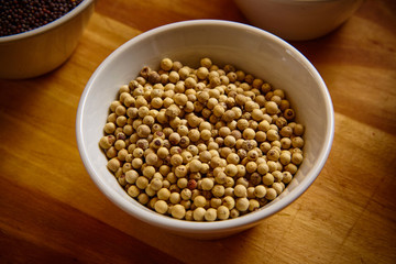 Muntok white pepper in white bowl on wooden background