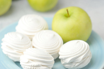 white marshmallows on a blue plate and green apples