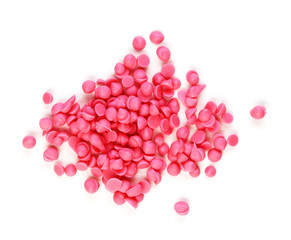 small pink chocolates on a white background. round candies are collected in one pile
