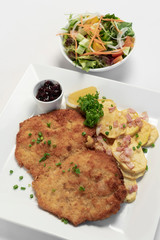 german breaded organic pork schnitzel with bacon fried potatoes
