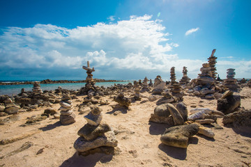 Stacked rocks balance on rocky beach in Aruba