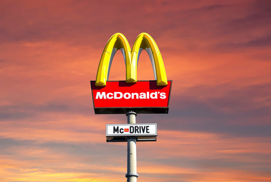 Herzogenaurach, Bavaria - August 13, 2017: McDonalds logo against sky. McDonald's Corporation is the world's largest chain of hamburger fast food restaurants.
