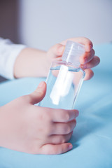 Child holding in a hand sanitizer. Antibacterial antiseptic. Prevent the virus and bacterias, hygiene and Covid-19 virus protection concept.