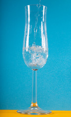 bicchiere di acqua su sfondo azzurro